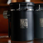 Load image into Gallery viewer, Stainless Steel Coffee Canister 21oz Airtight Kitchen Food Storage Container with Date Tracker CO2 Release Valve and Measuring Scoop For Ground Coffee Beans Tea Sugar Large (Black)